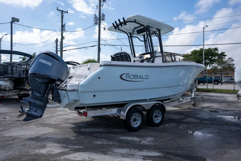 Slide: The Image of 2025 Robalo R230 boat with Yamaha engine on a trailer, parked outdoors. - 13