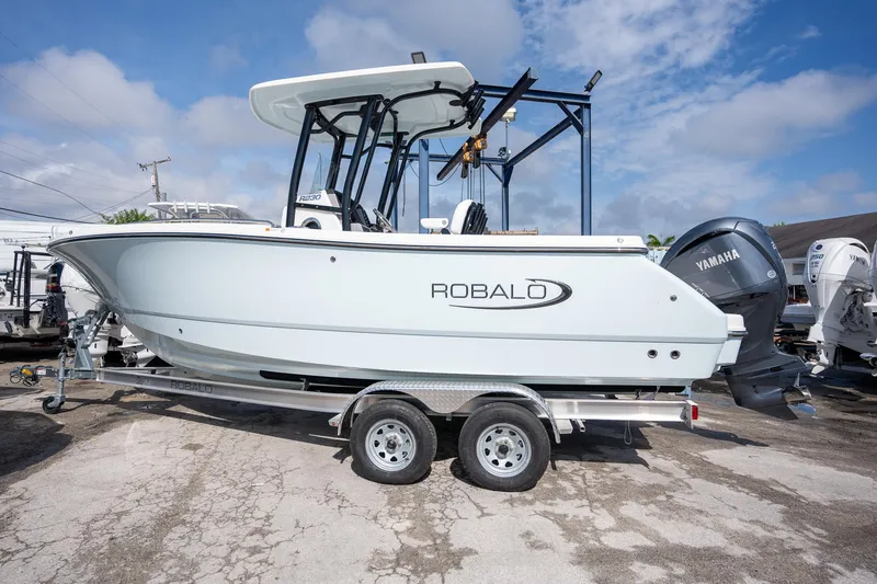 Slide: The Image of 2025 Robalo R230 boat on trailer with Yamaha engine, parked outdoors. - 15