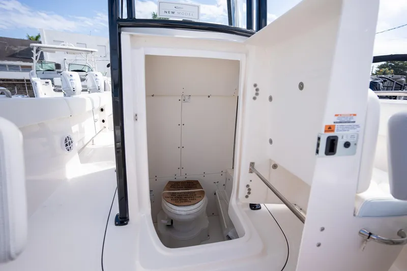 Slide: The Image of 2025 Robalo R230 boat interior with open compartment showing a marine toilet. - 4