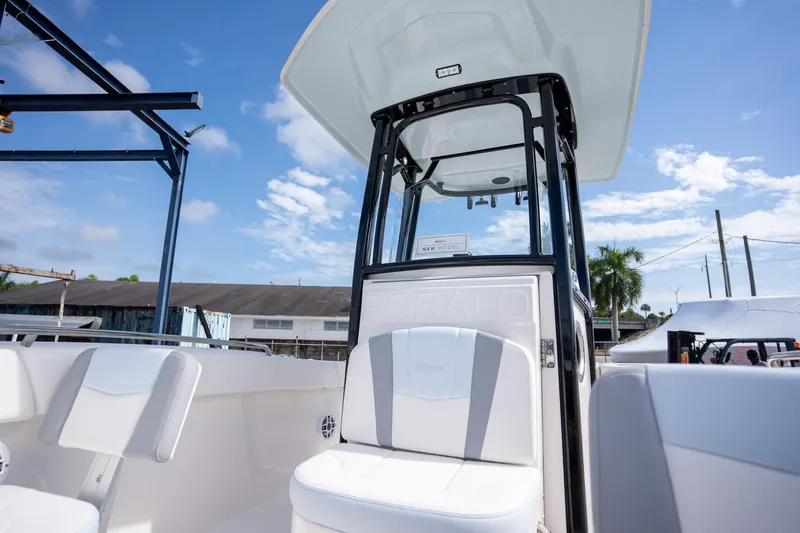 Slide: The Image of 2025 Robalo R230 boat interior with seating and console under a clear blue sky. - 5