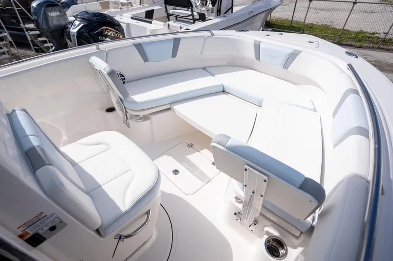 Slide: The Image of 2025 Robalo R230 boat interior with white seating and table, showcasing luxury design. - 7