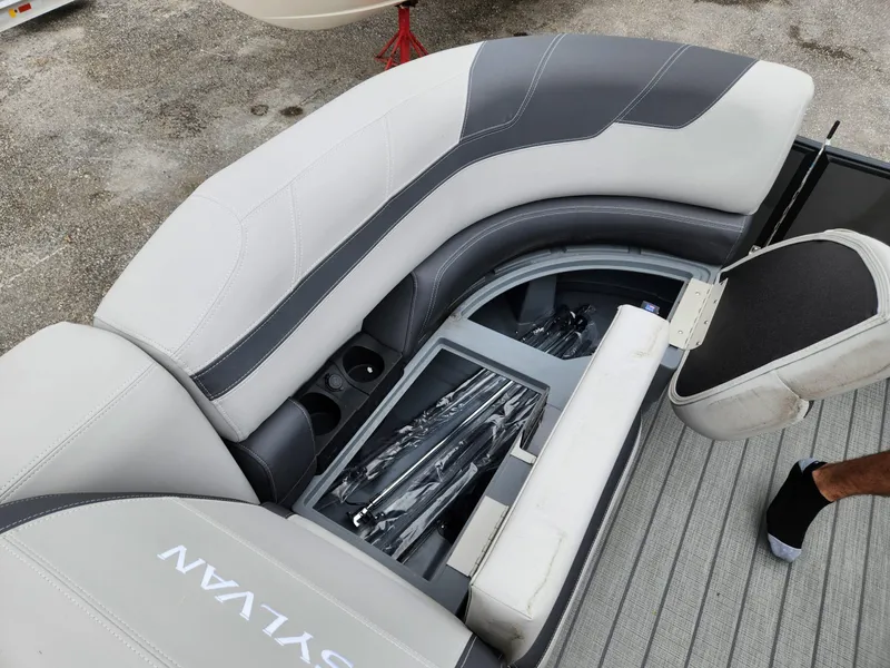 Slide: The Image of 2024 Sylvan L3 DLZ Bar boat interior with storage compartment and seating. - 11