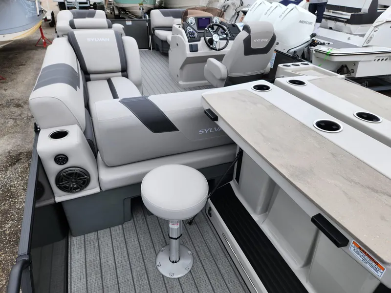 Slide: The Image of 2024 Sylvan L3 DLZ Bar pontoon boat interior with seating and bar area. - 6