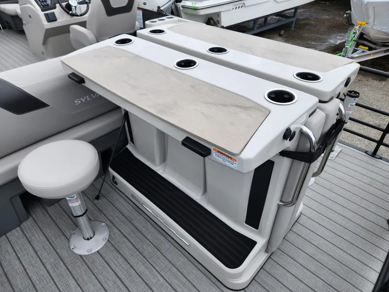 Slide: The Image of 2024 Sylvan L3 DLZ Bar with seating and integrated cup holders on a pontoon boat. - 7