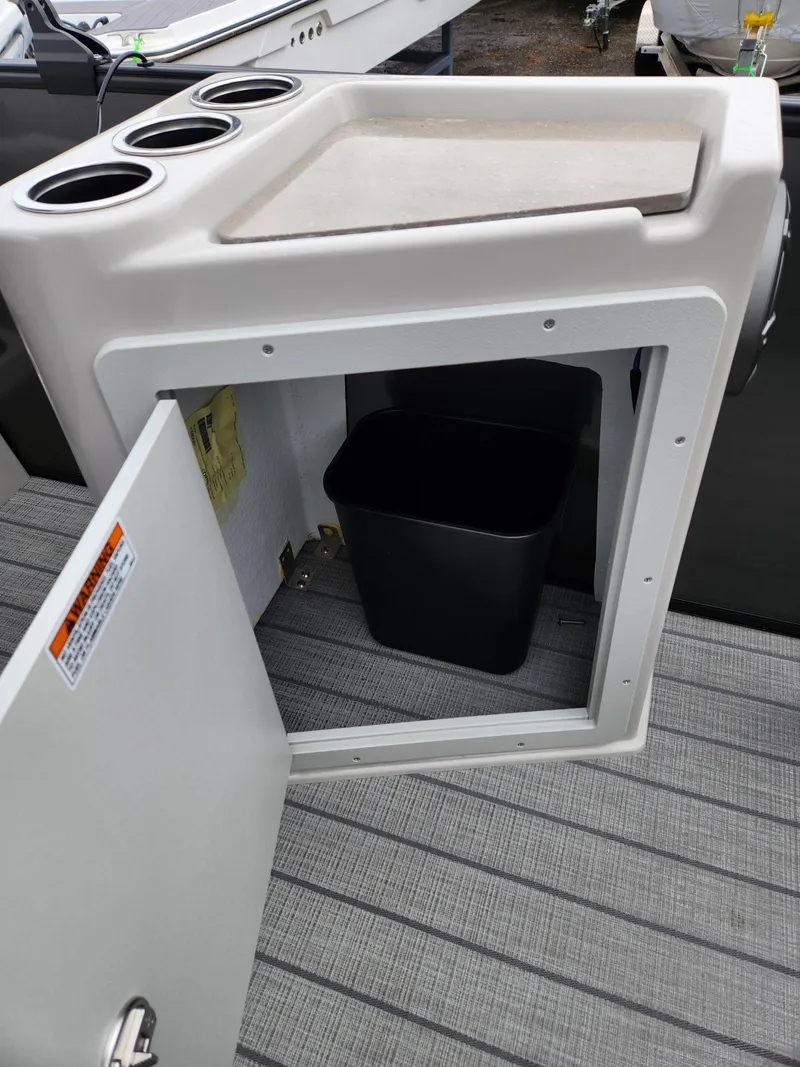 Slide: The Image of 2024 Sylvan L3 DLZ Bar with open storage compartment and trash bin. - 9