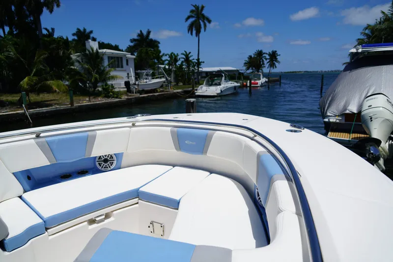 Slide: The Image of 2024 Robalo R360 boat with luxurious seating, docked near palm trees and waterfront homes. - 17