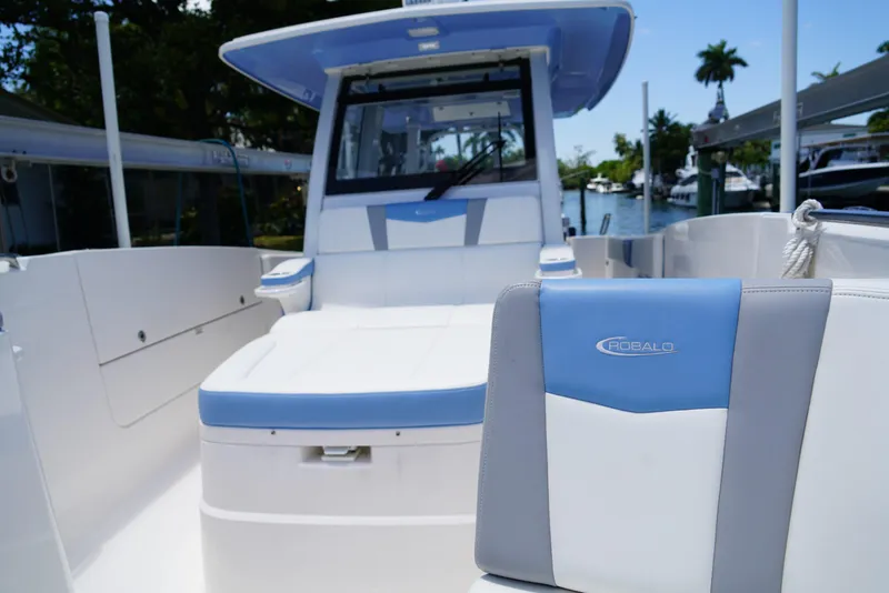Slide: The Image of 2024 Robalo R360 boat interior with blue and white seating, docked near water. - 21