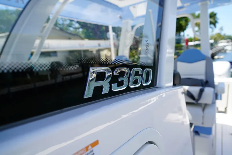 Slide: The Image of 2024 Robalo R360 boat, close-up of model name on sleek exterior. - 28