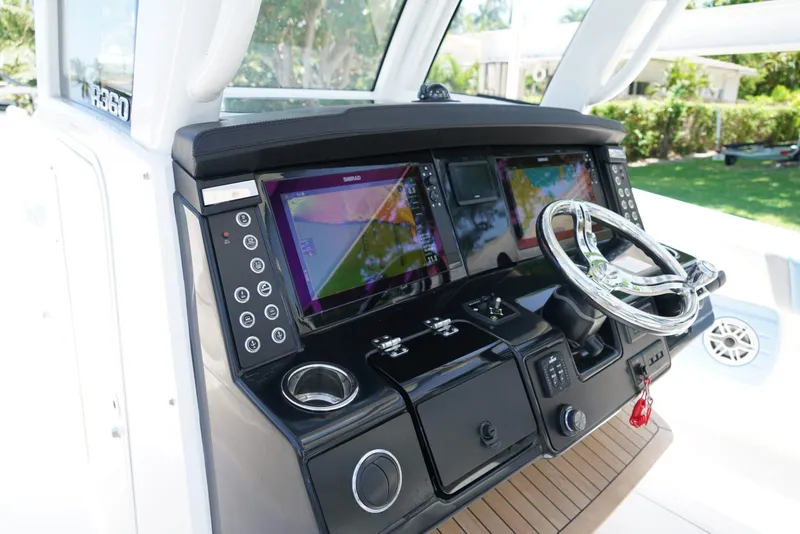 Slide: The Image of 2024 Robalo R360 boat dashboard with advanced navigation screens and sleek steering wheel. - 30