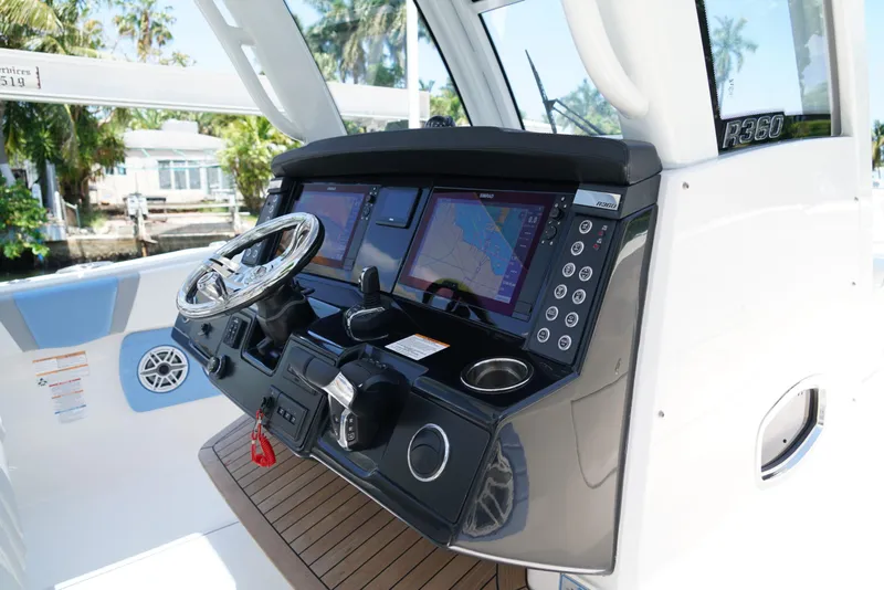 Slide: The Image of 2024 Robalo R360 boat dashboard with navigation screens and steering wheel. - 32