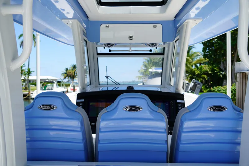 Slide: The Image of 2024 Robalo R360 boat interior with blue seats and modern dashboard. - 34