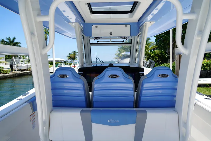 Slide: The Image of 2024 Robalo R360 boat interior with blue seating and modern dashboard. - 35