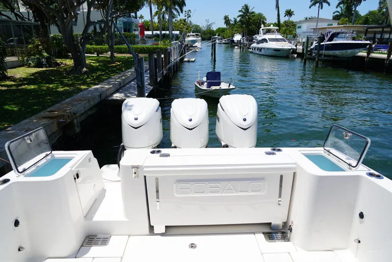 Slide: The Image of 2024 Robalo R360 boat with triple engines docked in a scenic marina. - 38