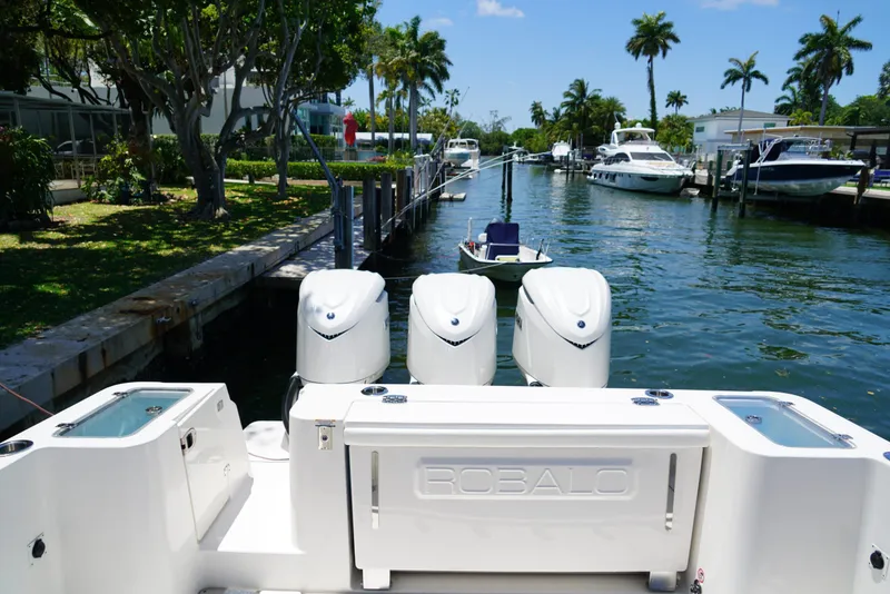 Slide: The Image of 2024 Robalo R360 boat with triple engines docked in a scenic canal. - 40