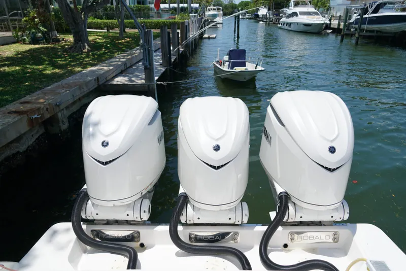 Slide: The Image of 2024 Robalo R360 boat with triple Yamaha outboard engines docked in a marina. - 47