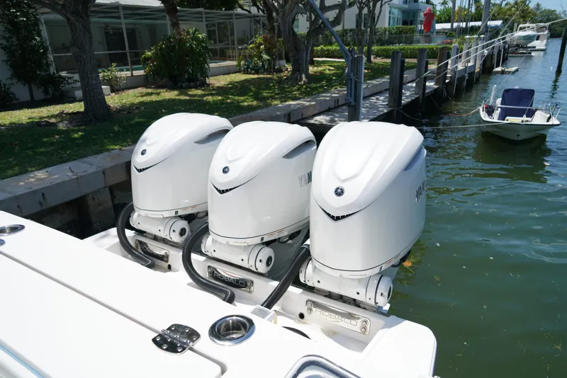 Slide: The Image of 2024 Robalo R360 boat with triple Yamaha outboard engines docked by the water. - 48