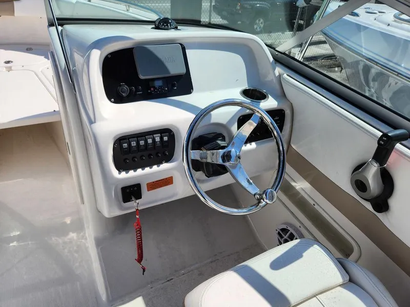 Slide: The Image of 2023 Robalo R227 boat dashboard with steering wheel and control panel. - 13
