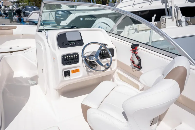 Slide: The Image of 2023 Robalo R227 boat cockpit with steering wheel and control panel. - 16