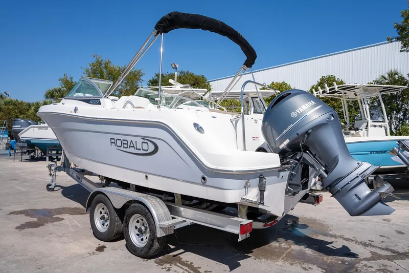 Slide: The Image of 2023 Robalo R227 boat on trailer with Yamaha outboard motor, parked outdoors. - 27
