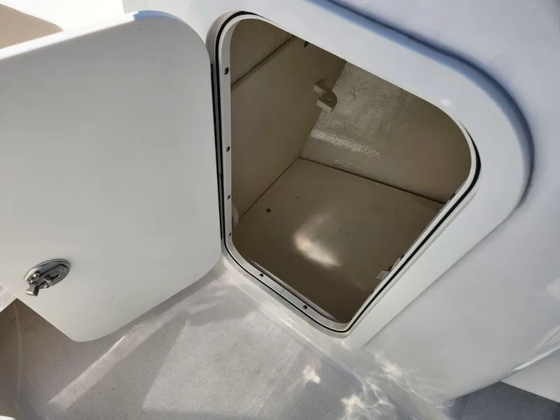 Slide: The Image of Open storage compartment on 2023 Robalo R227 boat, featuring a secure latch. - 8