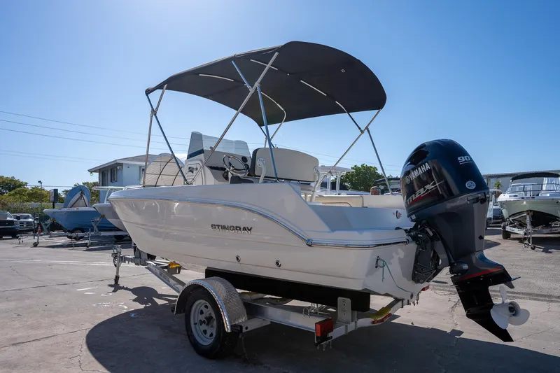 Slide: The Image of 2023 Stingray 173CC boat with Yamaha outboard motor on a trailer, parked outdoors. - 3