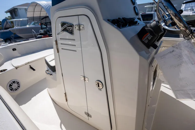 Slide: The Image of 2023 Stingray 173CC boat console with steering wheel and storage compartment. - 8