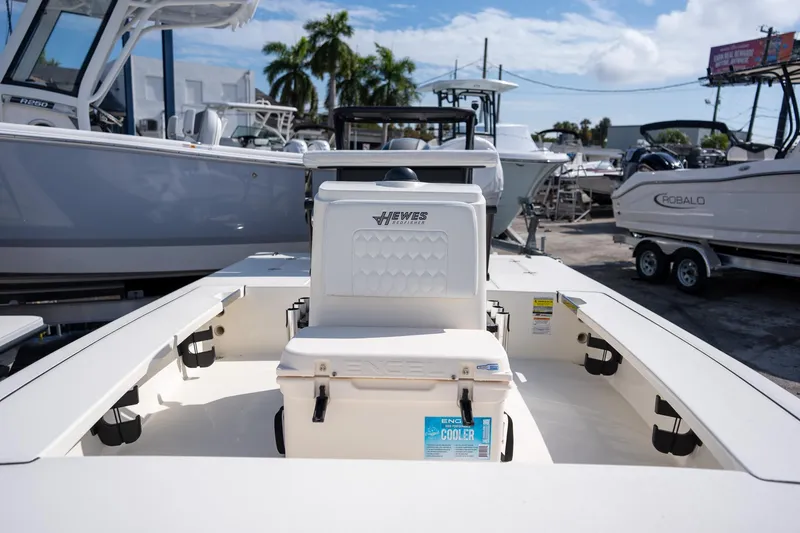 Slide: The Image of 2025 Hewes Redfisher 18 boat interior with cooler, parked at a marina. - 9