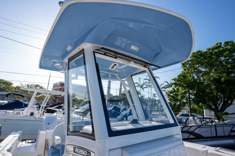 Slide: The Image of 2025 Robalo R250 boat with sleek design and modern features, docked under clear blue sky. - 10