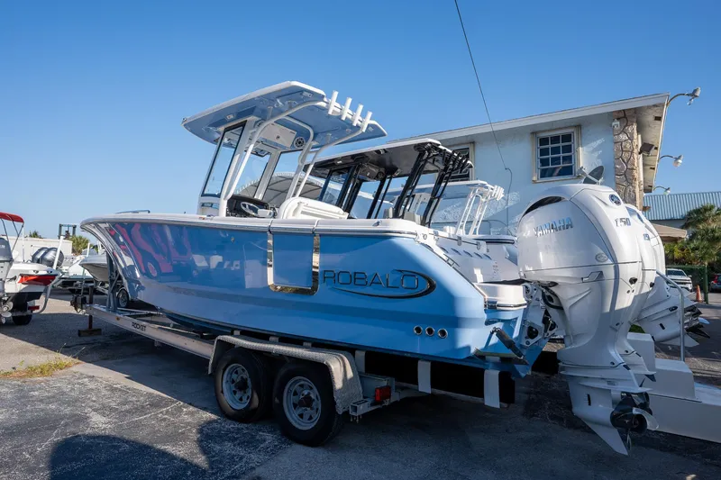 Slide: The Image of 2025 Robalo R250 boat on trailer with Yamaha engines, parked outdoors. - 3