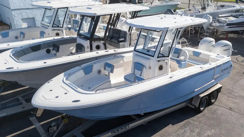 Slide: The Image of 2025 Robalo R250 boat on trailer, sleek design, white and blue color scheme. - 4