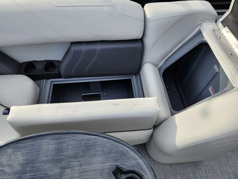 Slide: The Image of 2023 Sylvan X5 boat interior with open storage compartment and cup holders. - 13