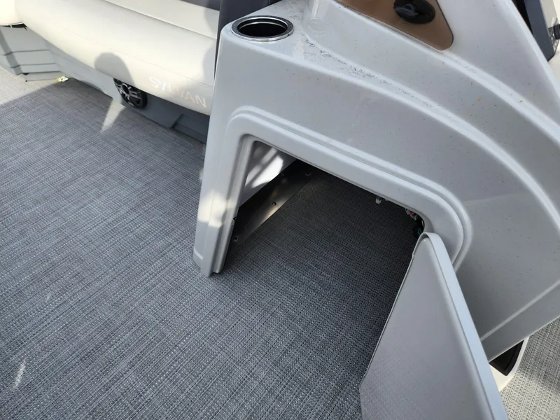Slide: The Image of 2023 Sylvan X5 boat interior with open storage compartment and cup holder. - 14