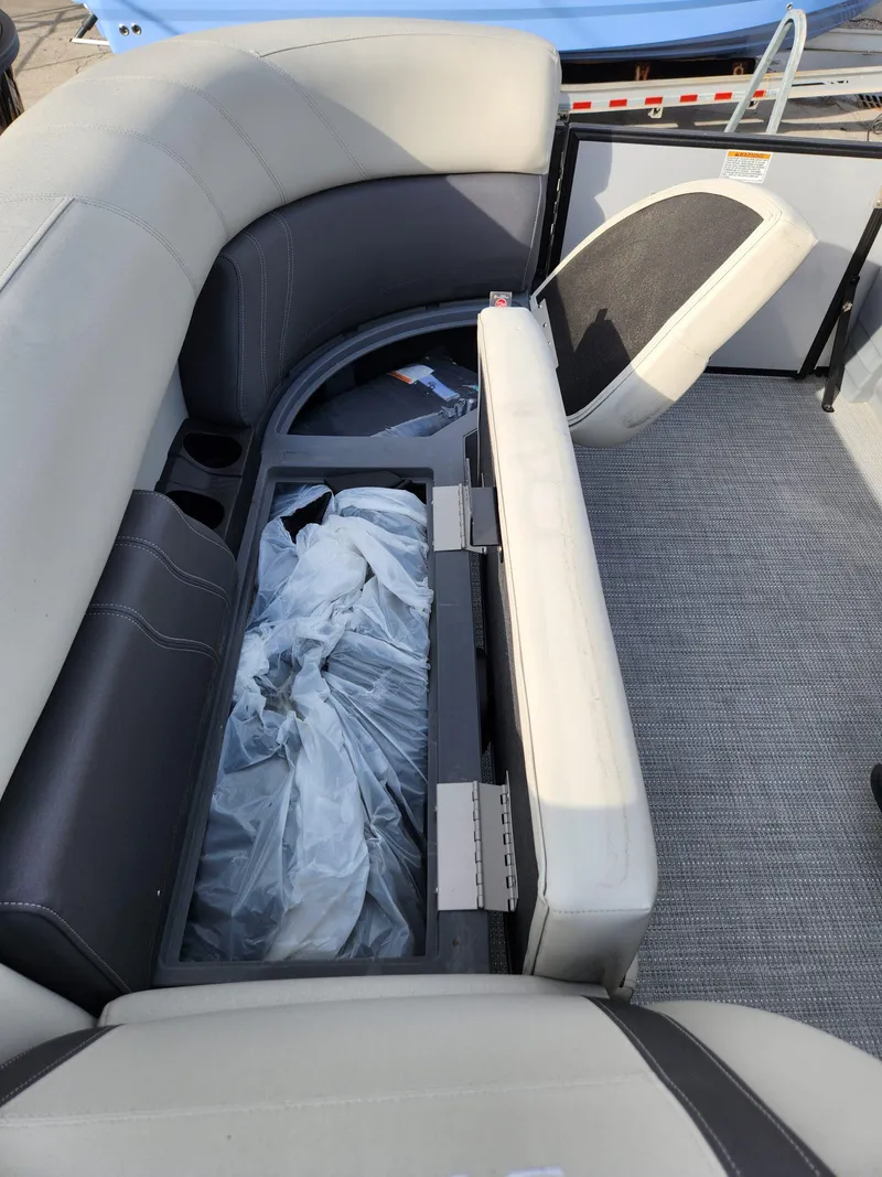Slide: The Image of 2023 Sylvan X5 boat interior with open storage compartment and cushioned seating. - 23
