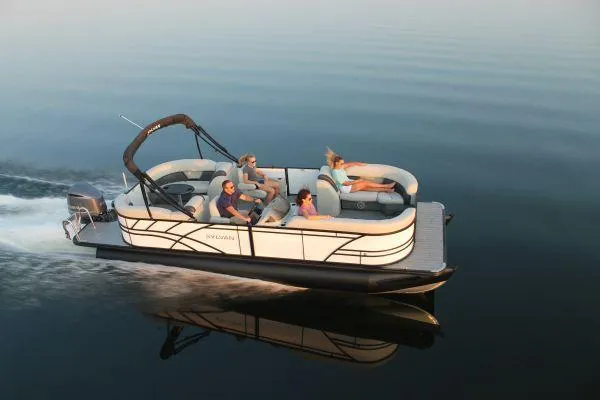 Slide: The Image of 2023 Sylvan X5 pontoon boat cruising on calm water with passengers relaxing. - 25