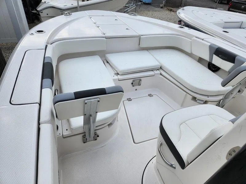 Slide: The Image of 2023 Robalo 266 Cayman boat interior with white seating and storage compartments. - 7