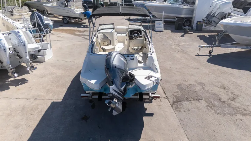 Slide: The Image of 2024 Stingray 211DC boat with Yamaha outboard motor in a marina setting. - 18