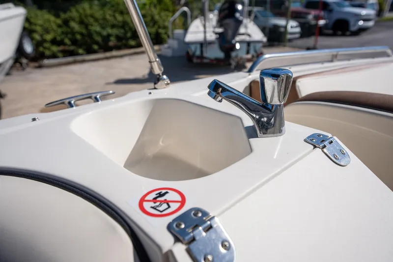 Slide: The Image of 2024 Stingray 192SC boat sink with chrome faucet and safety warning sticker. - 11
