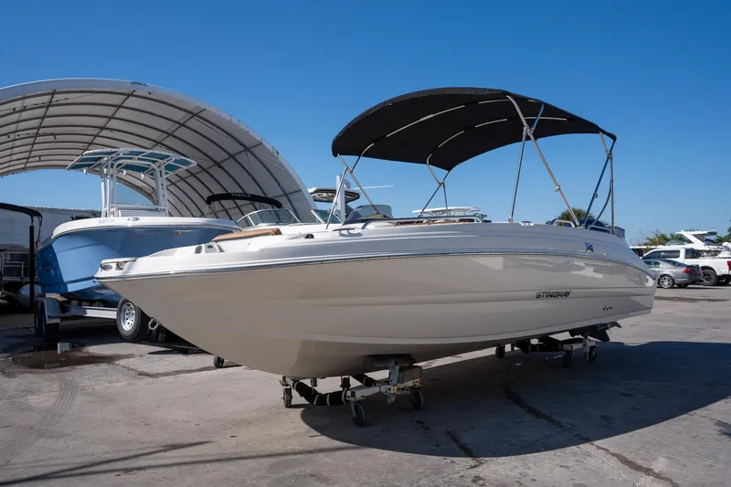 Slide: The Image of 2024 Stingray 192SC boat with canopy, parked outdoors under clear blue sky. - 3