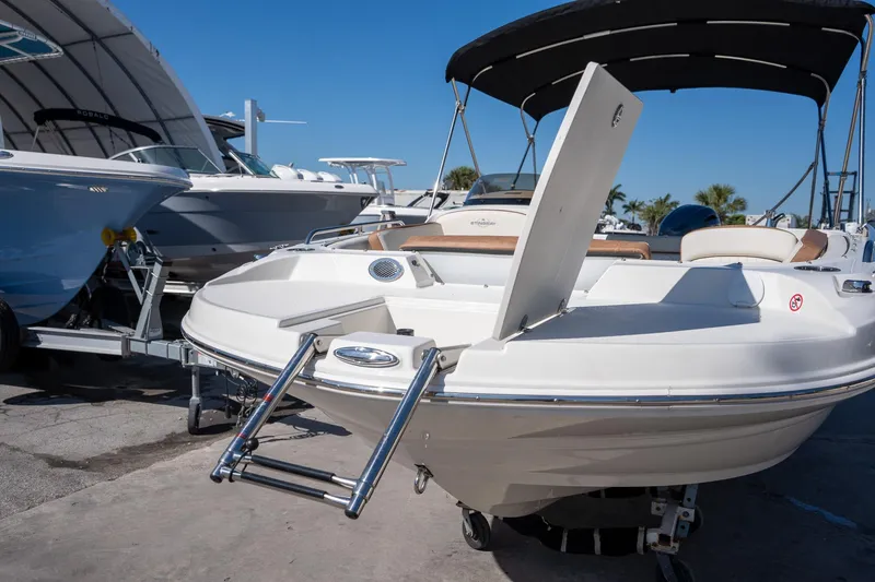 Slide: The Image of 2024 Stingray 192SC boat with ladder, docked under clear blue sky. - 5