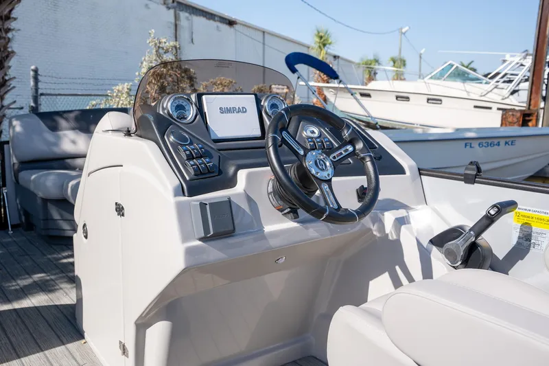 Slide: The Image of 2024 Sylvan L3 DLZ Bar boat dashboard with steering wheel and controls. - 10