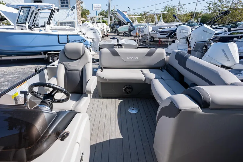 Slide: The Image of 2024 Sylvan L3 DLZ Bar pontoon boat interior with gray seating and steering wheel. - 13