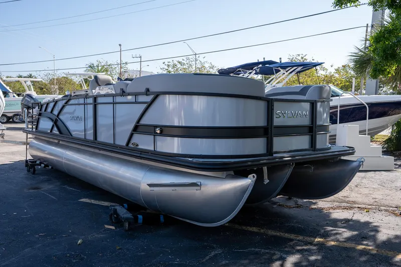 Slide: The Image of 2024 Sylvan L3 DLZ Bar pontoon boat displayed outdoors. - 2