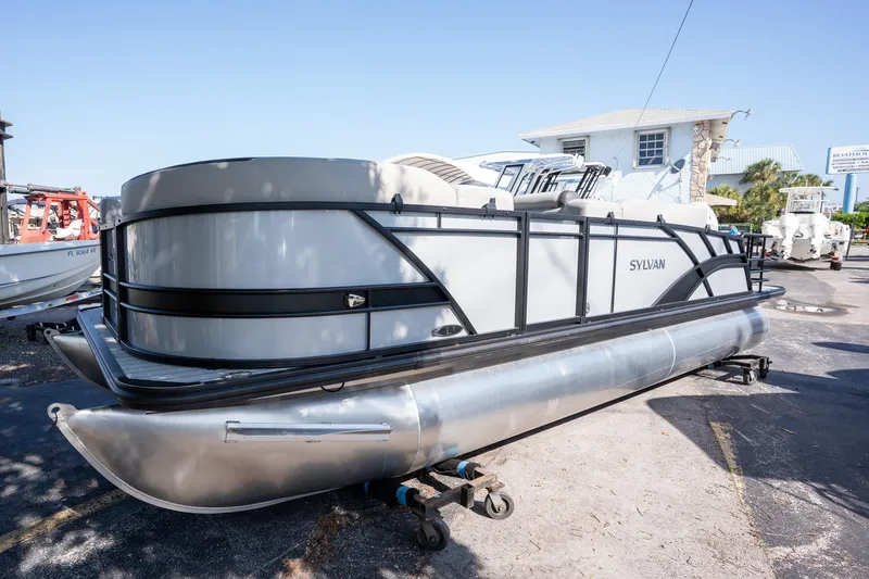 Slide: The Image of 2024 Sylvan L3 DLZ Bar pontoon boat on display outdoors. - 3