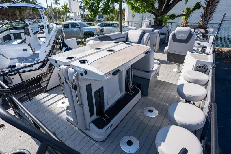 Slide: The Image of 2024 Sylvan L3 DLZ Bar pontoon boat interior with seating and bar area. - 5