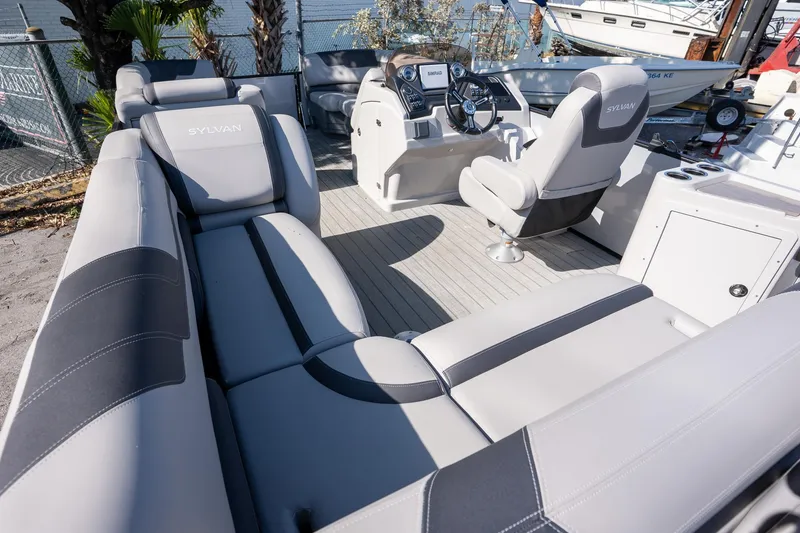 Slide: The Image of 2024 Sylvan L3 DLZ Bar pontoon boat interior with plush seating and modern helm. - 8