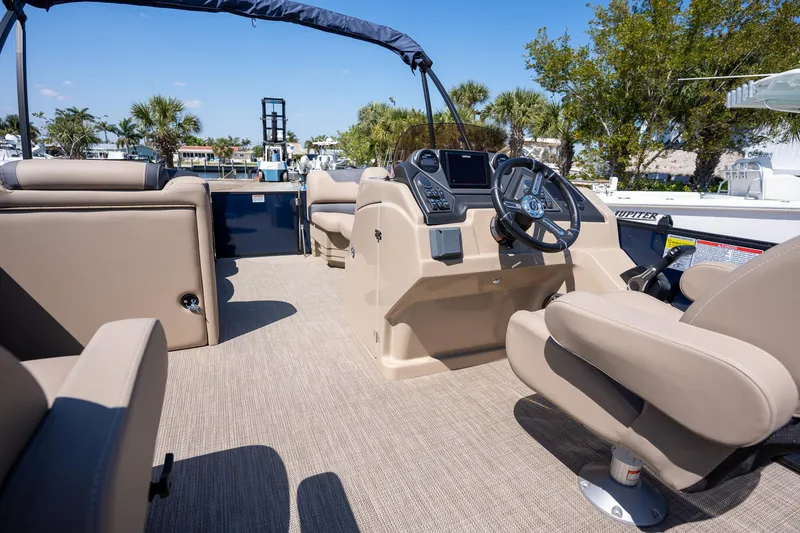 Slide: The Image of 2024 Sylvan L3 DLZ Bar boat interior with beige seating and steering console. - 17