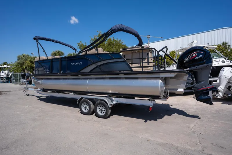 Slide: The Image of 2024 Sylvan L3 DLZ Bar pontoon boat on trailer, featuring Yamaha outboard motor. - 3