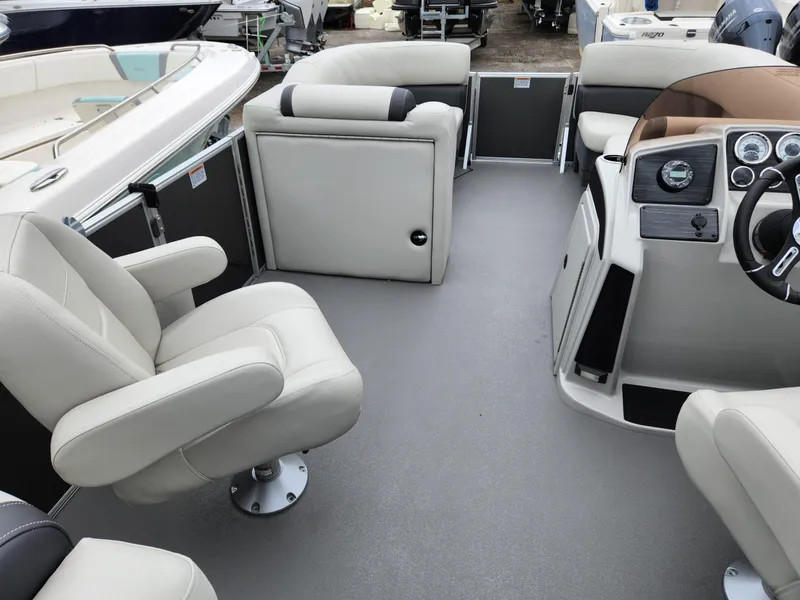 Slide: The Image of 2024 Sylvan 822 LZ boat interior with plush seating and modern dashboard. - 10