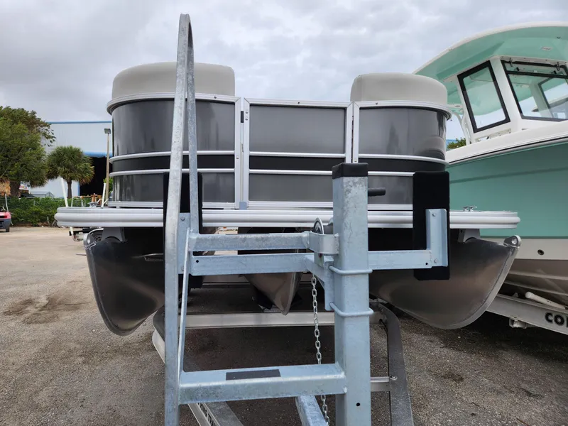 Slide: The Image of 2024 Sylvan 822 LZ pontoon boat on trailer, parked outdoors. - 6