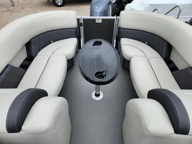 Slide: The Image of 2024 Sylvan 822 LZ pontoon boat interior with plush seating and central table. - 8